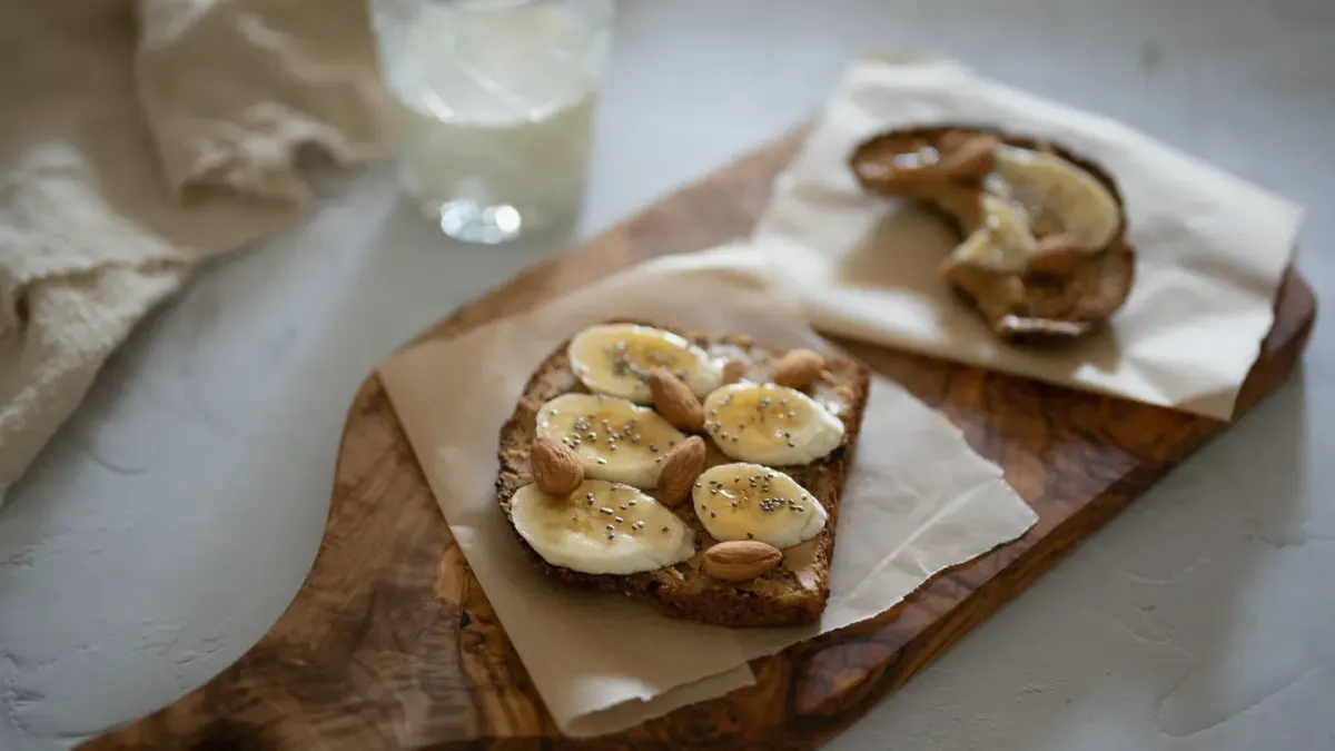 A sliced banana and soft chew treats arranged on a kitchen counter next to a small dog